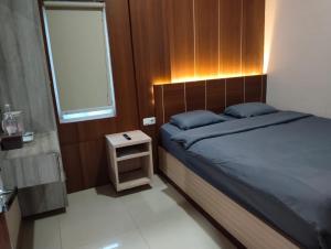 三宝垄J&L Inn Semarang的一间卧室配有床和小床头柜
