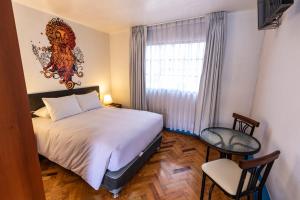 库斯科La Casona de Rimacpampa的一间卧室设有一张床、一个窗口和一把椅子