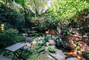首尔汉所总统套房韩屋酒店的一个带瀑布的花园内的桌椅