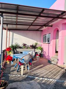 TānsenCity View Home Stay的一个带桌椅的庭院和一座粉红色的房子