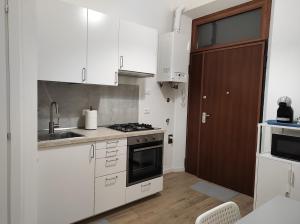 帕尔马KAIROS RESIDENCE的厨房配有白色橱柜和水槽