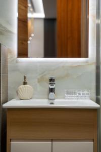 兹拉蒂博尔Mans lux 8 Apartman的浴室水槽、镜子和肥皂机