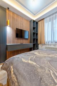 兹拉蒂博尔Mans lux 8 Apartman的一间卧室设有平面电视和一张床。