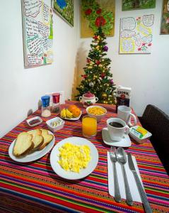 利马Mama Backpackers的一张带早餐食品的桌子和一棵圣诞树