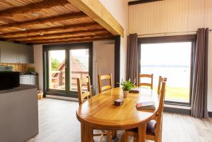 Doune Bay Lodge的一间带木桌的用餐室和一间厨房