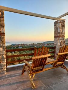 萨索斯Helicon Luxury Villas的两把木椅坐在一个美景阳台