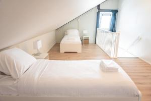 斯内克Marinaveste Campevaer的一间白色卧室,配有两张床和楼梯