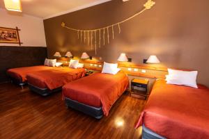 库斯科La Casona de Rimacpampa的酒店客房带两张带橙色床单的床