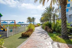 拉斯阿尔卡麦Beach Dream - a luxury 1 bedroom apartment with direct beach access的一条棕榈树和海滩小径