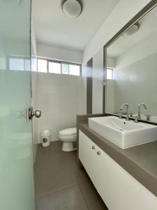 帕拉卡斯Condominio Nuevo Paracas - Sotavento的白色的浴室设有水槽和卫生间。