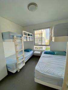 帕拉卡斯Condominio Nuevo Paracas - Sotavento的一间卧室设有两张双层床和一扇窗户。