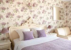 戛纳Croisette Palais Miramar Cannes Imperial的一间卧室配有一张紫色花卉大床