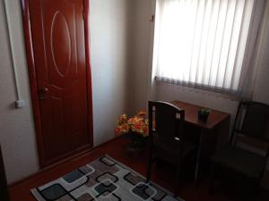 杜尚别Sayfi Guesthouse的一间设有门、椅子和桌子的房间
