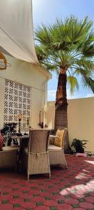 迪拜Jumeirah Beach Villa的一间设有桌子和棕榈树的客房