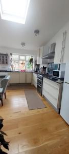 牛津Comfortable artistic house welcomes you!的厨房铺有木地板,配有白色橱柜。