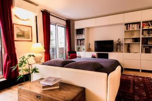 巴黎Paris-Daumesnil - Grand 2 pieces 4 etoiles de charme sur jardin - 61m2, pour 4p - Large 4 star charming 1 BR apt for 4 with AC的一间带大床和电视的卧室