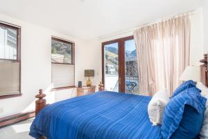特柳赖德Breathtaking Ballard Views的一间卧室设有蓝色的床和大窗户