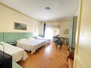 博洛尼亚Hotel Panorama Bologna Centro的酒店客房设有两张床和一张桌子。
