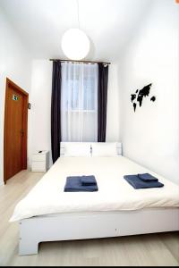 波尔塔瓦Atlas Hotel的卧室配有白色床和黑色毛巾