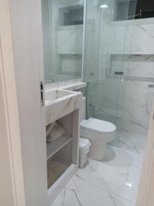 伊塔佩马Winter X locações 03的白色的浴室设有卫生间和淋浴。