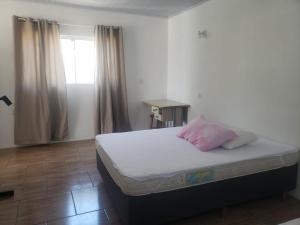 特拉曼达伊Apartamentos de Verão的一间卧室配有一张带粉红色枕头的床