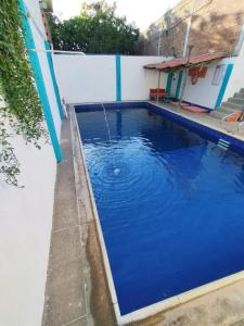 塔甘加Sierraventura Hostel的蓝色的游泳池,设有喷泉
