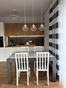 耶莱尼亚古拉APARTAMENT Berlińska 43的厨房配有桌子和两把白色椅子