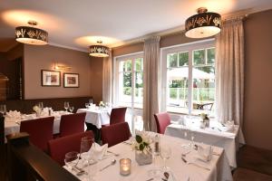 Emstek瓦德舒餐厅酒店的一间设有白色桌子和红色椅子的餐厅