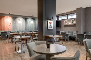 科斯拉达科斯拉达机场万豪AC酒店的用餐室设有桌椅和窗户。