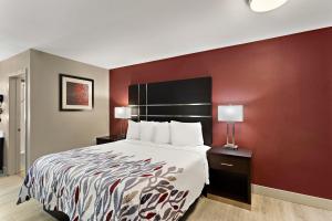 雷丁Red Roof Inn Redding的酒店客房,设有床铺和红色的墙壁