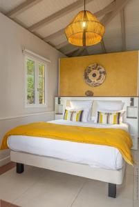 莱特鲁瓦西莱套房别墅酒店的一间卧室配有一张大床和一个吊灯。