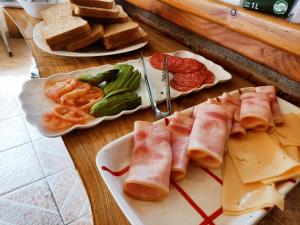 普孔Cabañas Santa Maria Pucon的一张桌子,上面有三盘食物,包括肉类和奶酪