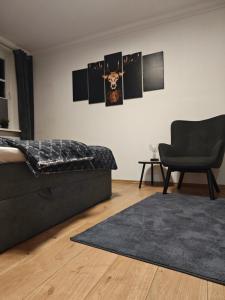 温特贝格Ferienwohnung Platzhirsch für 2 - 4 Pers.的一间卧室配有一张床、一把椅子和地毯