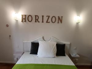拉特里尼泰Zen 972的一间卧室,配有一张带阅读线标牌的床