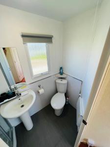 英戈尔德梅尔斯Fantasy Island Caravan Hire- Located at Fantasy Island- Eastgate Caravan Park, Sea Lane, Ingoldmells的浴室配有白色卫生间和盥洗盆。