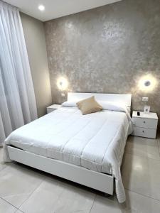 圣欧费米亚拉默齐亚B&B VIRGILIO LAMEZIA AIRPORT的卧室配有白色的床和灰色的墙壁