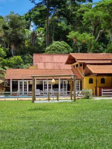 伊泰帕瓦VILLA MIA DUO的一座黄色的房子,有红色的屋顶和院子