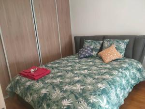 维勒瑞夫Appartement in Villejuif (M 7) with free parking的一张带绿色和白色棉被的床,上面有钱包