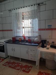 布希奥斯Casa Azul-Paraíso em Búzios的厨房配有水槽和炉灶