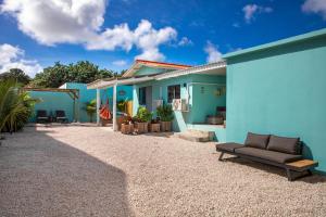 克拉伦代克Playa Feliz Apartments Bonaire的蓝色房子前面有沙发