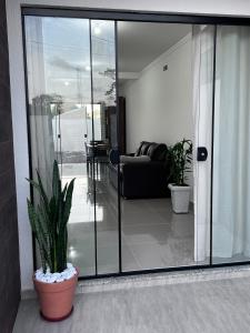 南圣弗朗西斯科Brisas de São Chico - 450m da Praia的一间设有玻璃门和盆栽的客厅