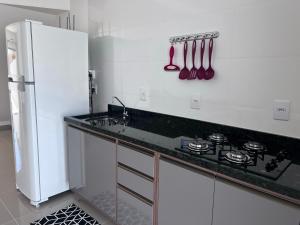 南圣弗朗西斯科Brisas de São Chico - 450m da Praia的白色的厨房配有炉灶和冰箱。
