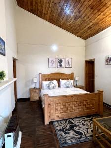 穆里Umda Hotel Pine Top的一间卧室设有一张大床和木制天花板