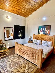 穆里Umda Hotel Pine Top的一间卧室配有一张大木床和镜子