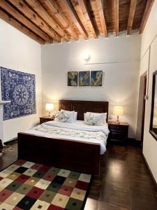 穆里Umda Hotel Pine Top的一间卧室配有一张床、两盏灯和地毯。