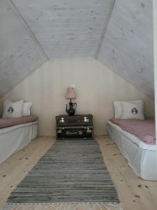 斯塔德Hus i mysig by nära havet的客房设有两张床和一张带台灯的桌子。