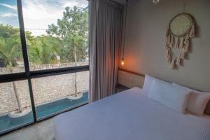 图卢姆BAU Tulum的一间卧室设有一张床和一个大窗户