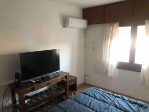 胡宁Departamento muy amplio, 3 habitaciones, 2 baños!的一间卧室配有一张床和一台平面电视