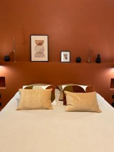 尼姆La Halte des Arènes de Nîmes Appartement de charme Terracotta的卧室配有一张带两个枕头的大白色床