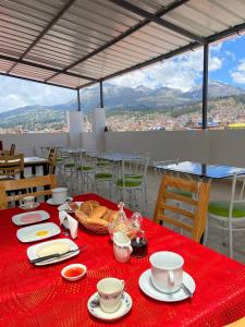 瓦拉斯Hotel Los Pajonales的一张桌子,上面有红色的桌布,上面有杯子和盘子